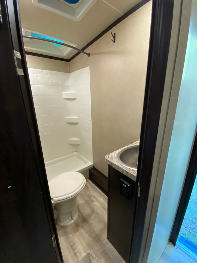 The trailer's full bathroom with shower, toilet and sink